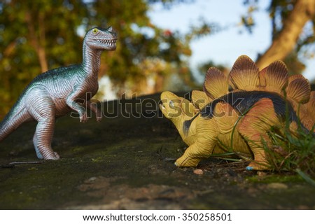 Toy dinosaur figurine in a real nature scenery outdoors.