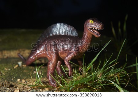 Toy dinosaur figurine in a real nature scenery outdoors