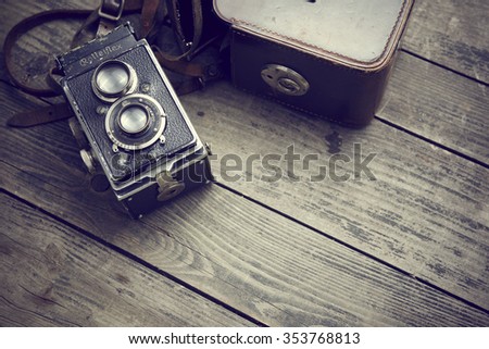 Czech Republic summer 2015 : Old retro camera Rolleiflex and belt bag (leather case) on vintage wooden boards. Illustrative Editorial