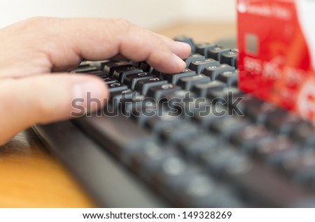 Male hands entering credit card information into a computer