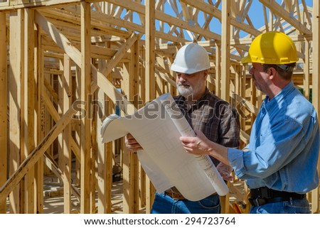 Two men looking at plans on construction site