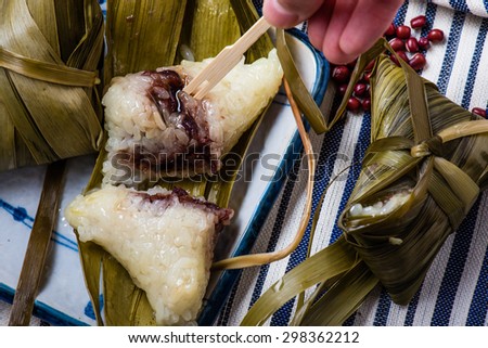Eating Unwrapped Zongzi, Chinese Sticky Rice Dumplings Wrapped on top of Bamboo Leaves