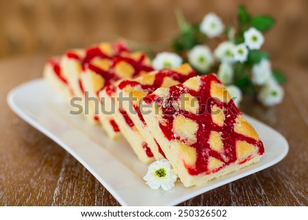 cakes on a white plate which costs on a table, lie flowers nearby