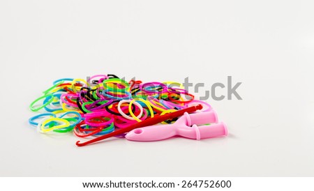 Fixtures for weaving bracelets from rubber bands lie close to the colored rubber bands