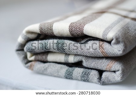 grey and brown checkered knitted folded blanket
