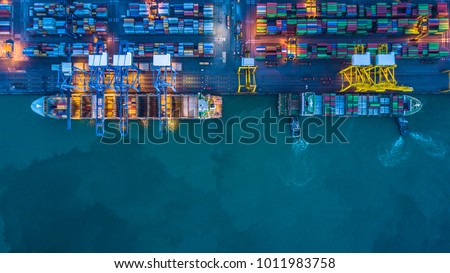 Aerial top view of container cargo ship in import export logistic at night.
