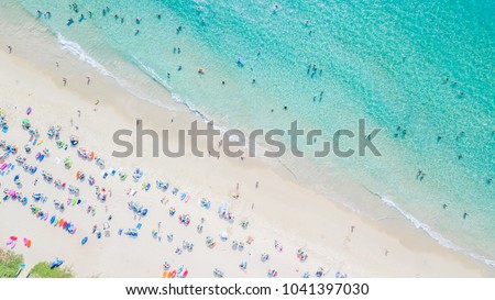 People bathing in the sun, swiming and playing games on the beach. Tourists on the sand beach, Aerial view of sandy beach with tourists swimming in beautiful clear sea water.