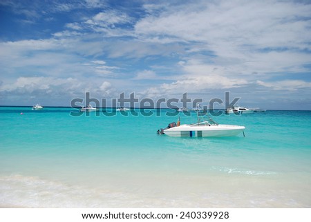 Boats anchored off Maldives on clean blue water.