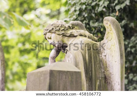 Statue of a contemplative angel. Olsany Cemetery, the largest graveyard in Prague, Czech Republic. Summer time