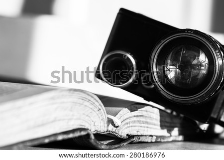 Open book and an ancient video camera. Black and white photo