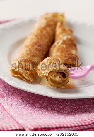 Rolled pancakes with honey, sugar and cinnamon. Tasty breakfast. Selective focus.