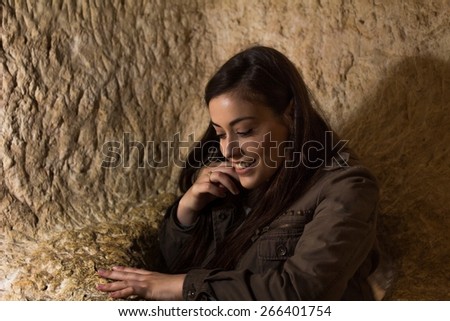 Photo of a smiling girl going out of a hole inside a cave