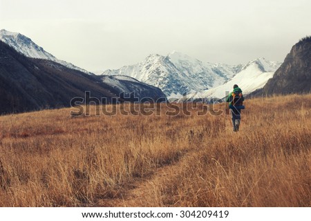 Backpacker go into the mountains. Happy travel concept. Mountain trekking. Man in harmony with nature. Autumn mountain landscape.