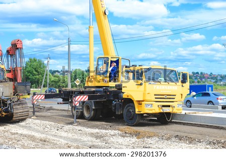 Saransk Russia - July 19: Auto crane Kamaz 55713-1. Crane driver works to set precast concrete piles for repair road, on July 19th 2015 in Saransk.