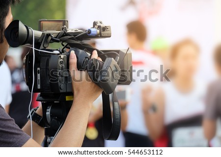 Photographer video recording activity within the event