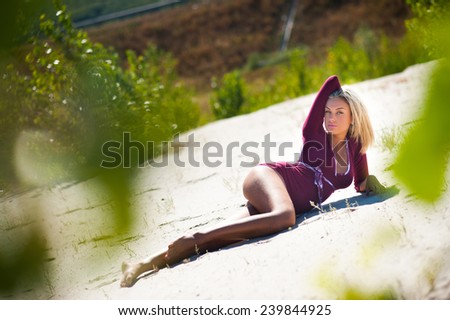 Sexy young woman laying relaxing posing on sand beach in summer on sunny day
