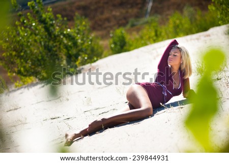 Sexy young woman laying relaxing posing on sand beach in summer on sunny day