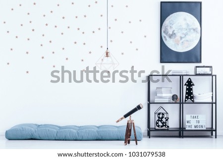 Simple kid\'s bedroom interior with star wallpaper and blue mattress on the floor next to a telescope