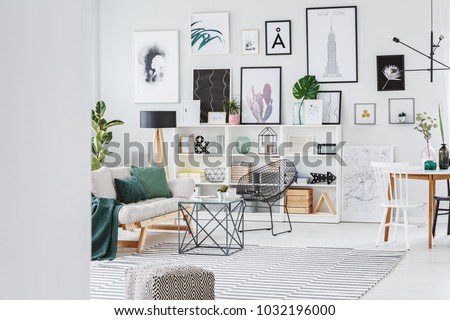 Bright, stylish living room interior with grey sofa, gallery and decor