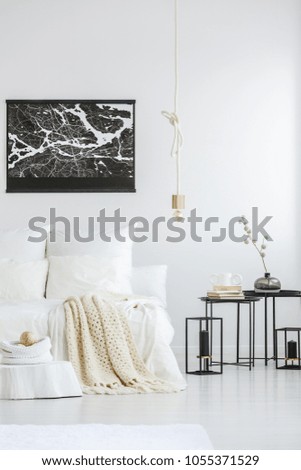 Black city map poster, a creative rope pendant light and industrial, box frame side tables in a white, minimalist bedroom interior