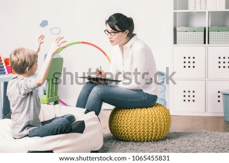 Excited boy and young teacher during private language lesson at home