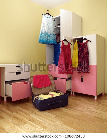 Preparing for holiday, packing girl\'s suitcase