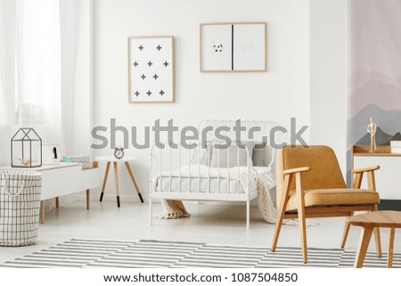 Minimalist framed posters on a white wall in a nordic style child\'s bedroom interior with designer decor and modern furniture