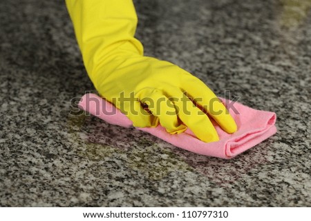 Hand in glove with rubber washing a floor