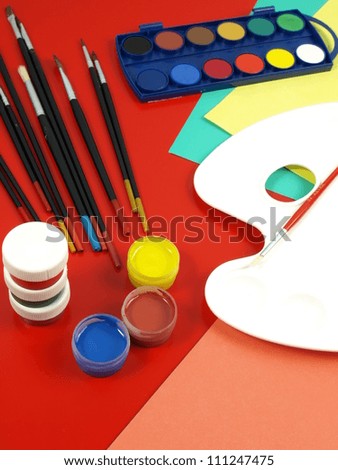 Colorful paint, brushes and palette in painting workshop