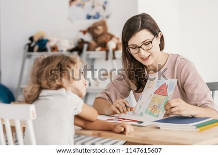 A professional child education therapist having a meeting with a kid in a family support center.