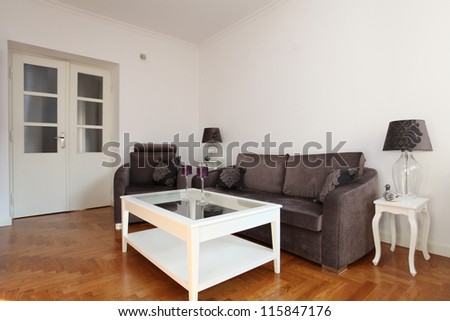 Bright living room with violet sofa and armchair