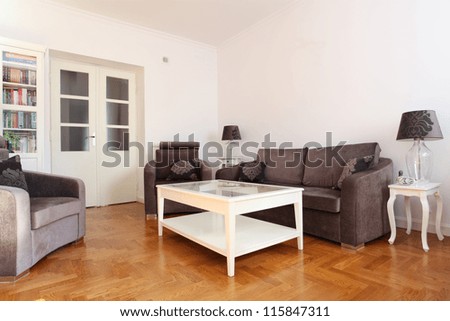 Spacious living room with wooden floor and bright walls