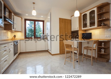 View Of Traditional Kitchen In Beige Color With Television