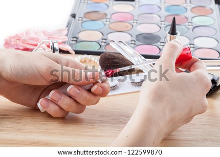 Doing makeup with pink gloss and colorful eye shadows