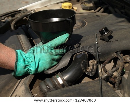Man hand pouring oil in car engine