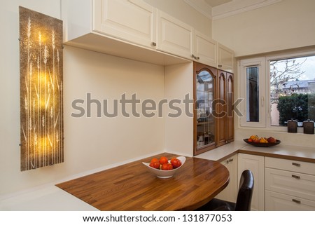 Cloudy home - functional furnished kitchen interior with a wooden table.