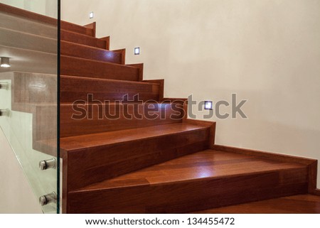 Travertine house- Horizontal view of brown, wooden stairs in luxury interior