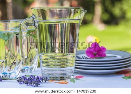 Table with cool drinks and plates for party