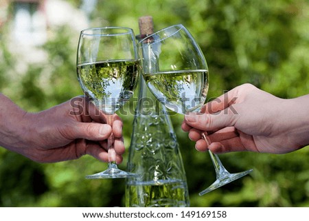 Hands of two people holding glasses with wine