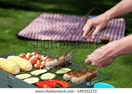 A man cooking food for a summer lunch in the garden