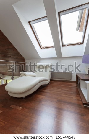 Modern room on the attic with comfortable seat