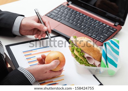Man at his desk eating an apple during work