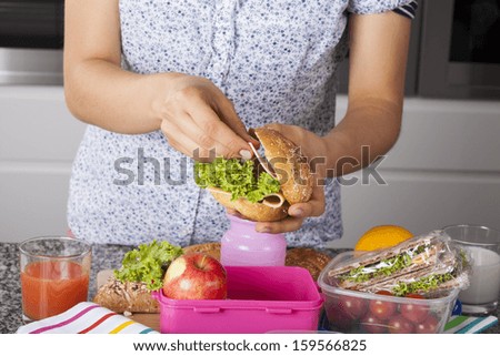 Mum preparing her child second meal for school