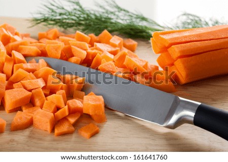 Chopped carrot with knife on the cutting board