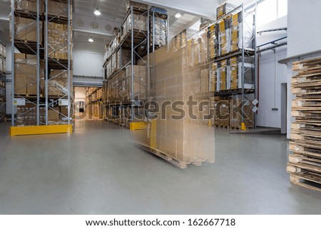 Spacious warehouse full of carton boxes on stillage