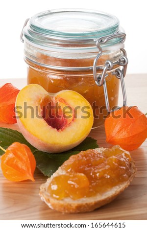 Peach jam in the jar and delicious sandwich with confiture