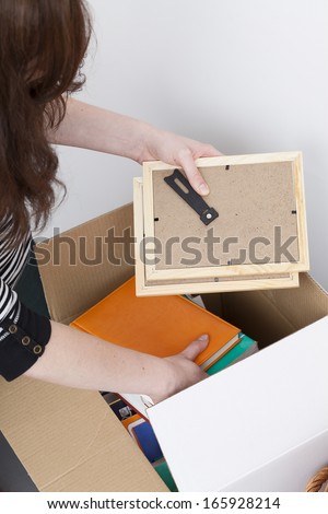 Woman packing photo frames into white box