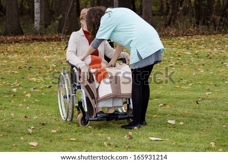 Young nurse caring of elder disabled woman