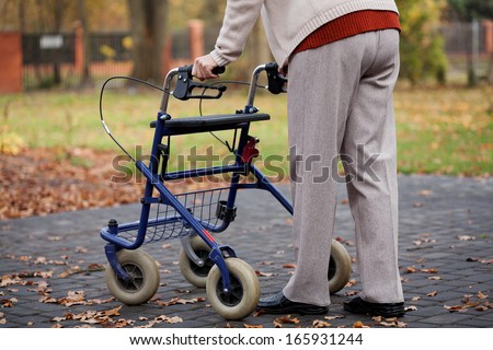 Disabled elder person walking with walker