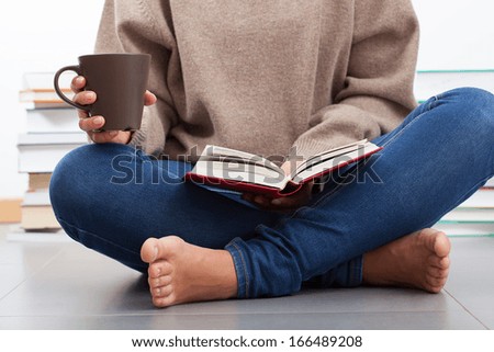 Woman sitting on a floor and reading a book
